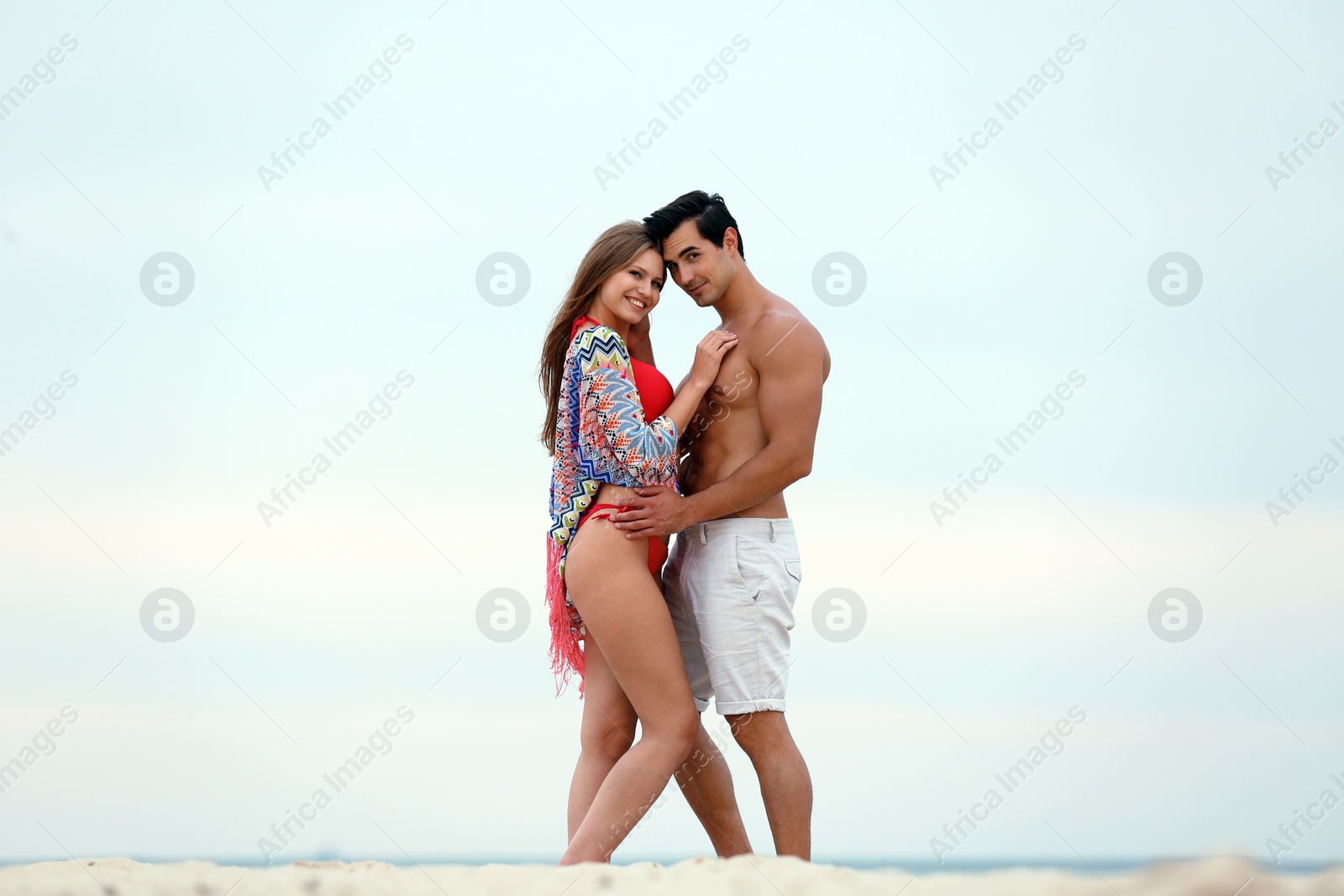 Photo of Happy young couple spending time together on sea beach