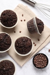 Photo of Tasty chocolate muffins on white marble table, flat lay