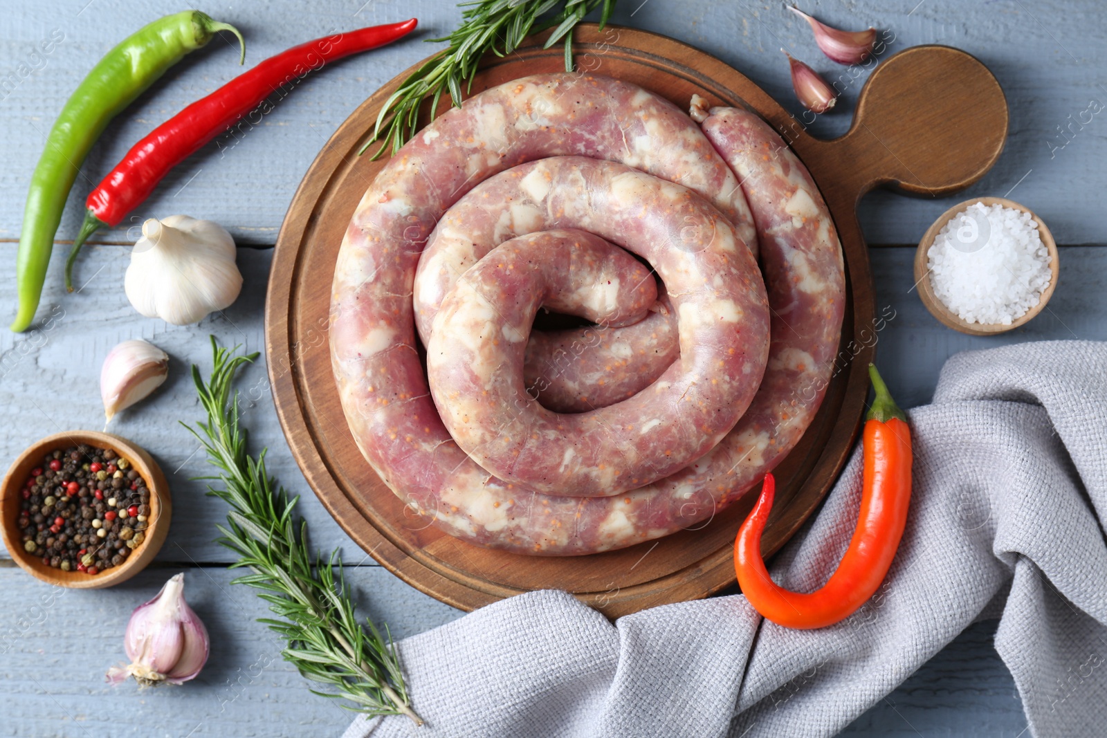 Photo of Flat lay composition with homemade sausages and products on light grey wooden table