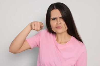 Photo of Aggressive young woman pointing on light grey background