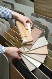 Man with samples of wooden flooring in shop, closeup