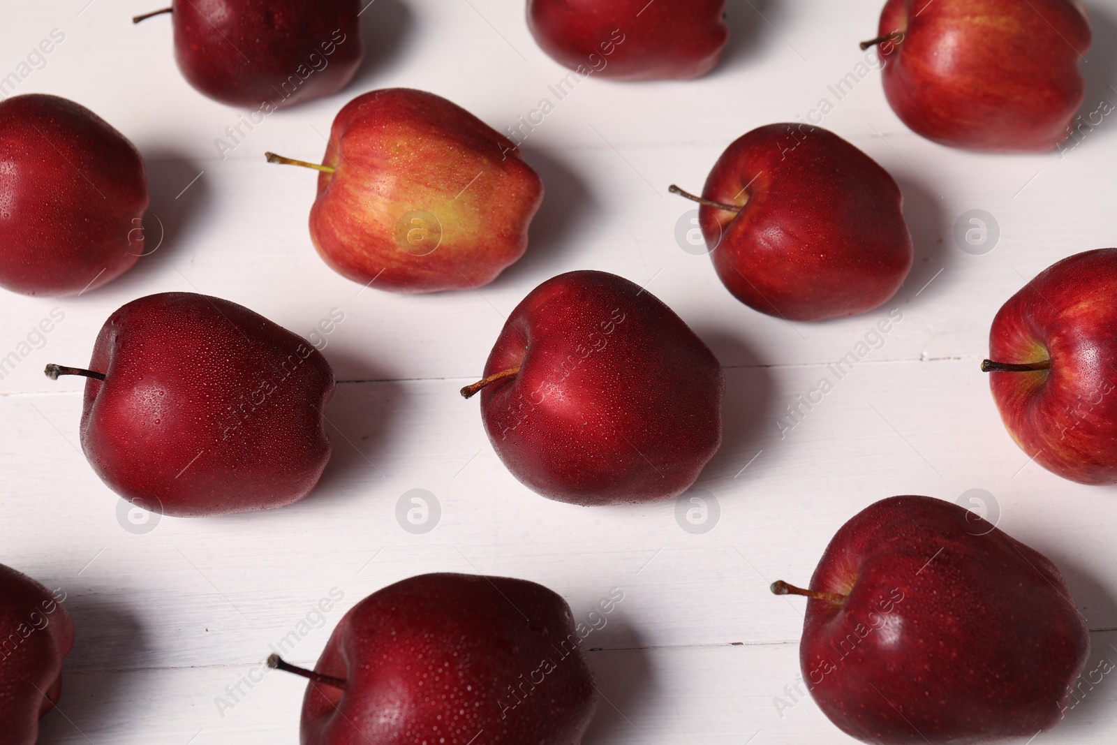 Photo of Fresh red apples with water drops on white wooden table