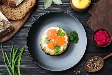 Delicious homemade chicken aspic served on black wooden table, flat lay