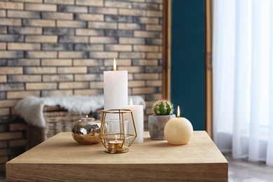 Burning candles on table indoors. Interior decor element