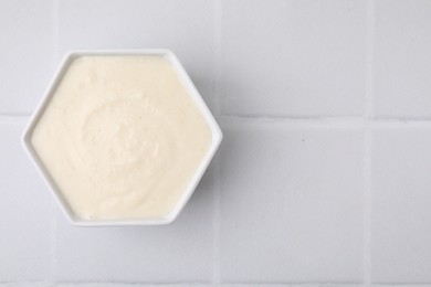 Photo of Bowl of delicious semolina pudding on white table, top view. Space for text