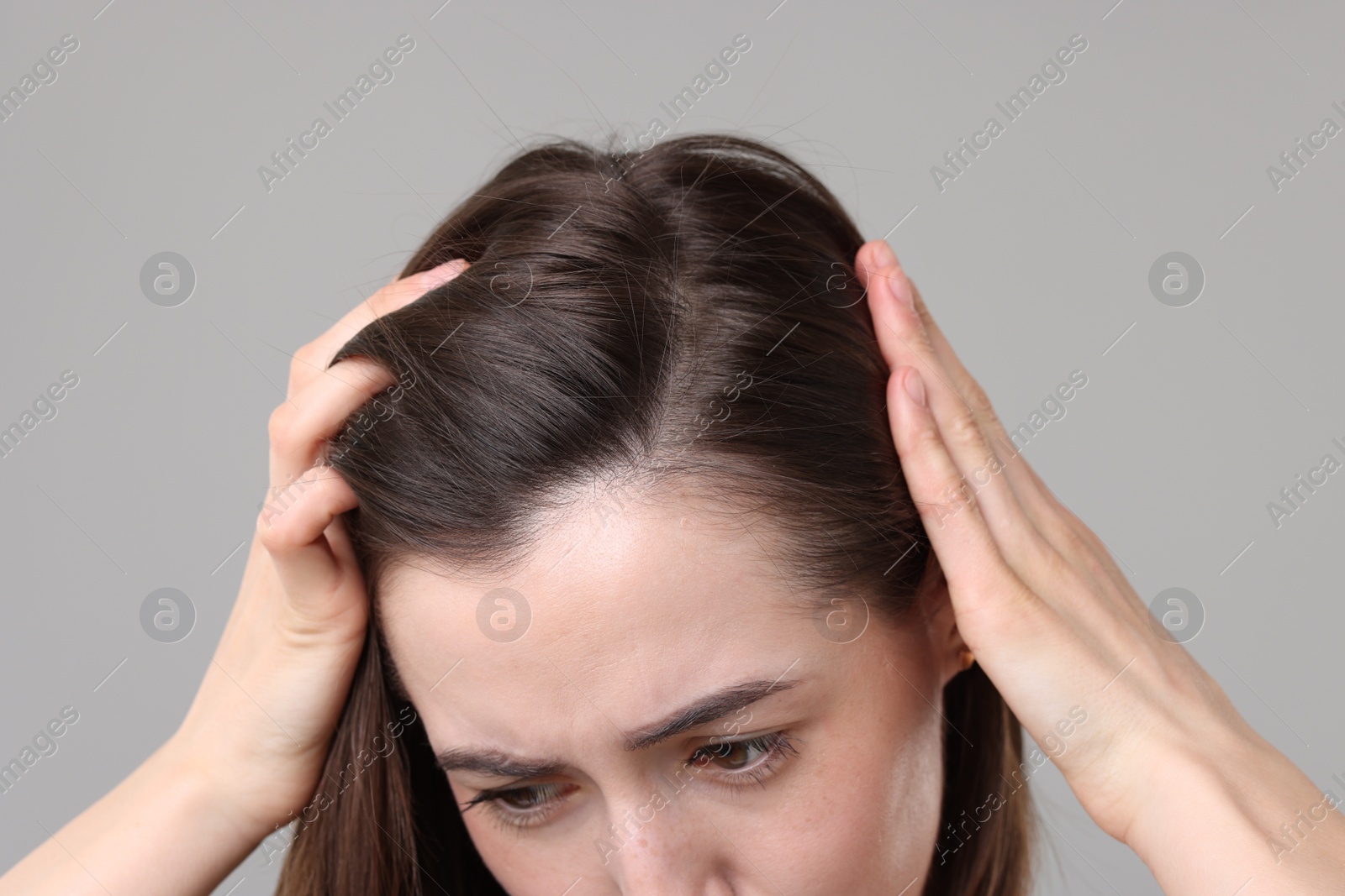 Photo of Sad woman with hair loss problem on grey background, closeup