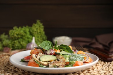 Photo of Delicious salad with mayonnaise on wicker mat