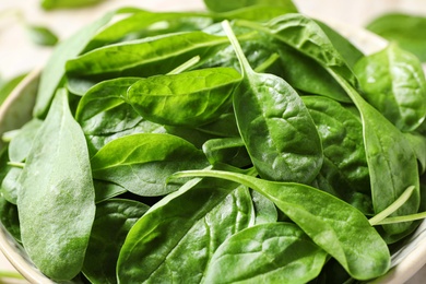 Photo of Fresh green healthy spinach in bowl, closeup