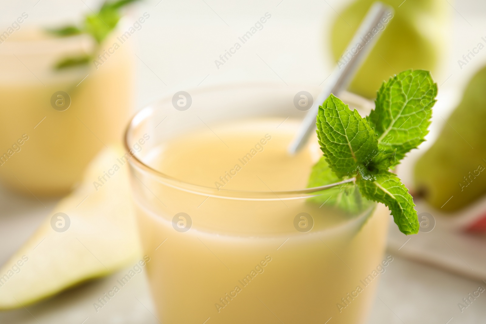 Photo of Tasty pear juice with mint in glass, closeup