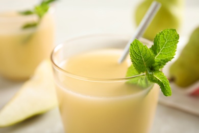 Photo of Tasty pear juice with mint in glass, closeup