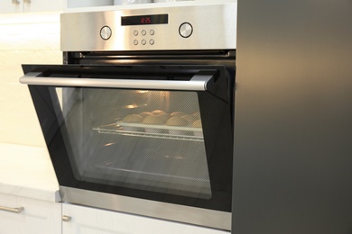 Photo of Baking pan with cupcakes in modern oven