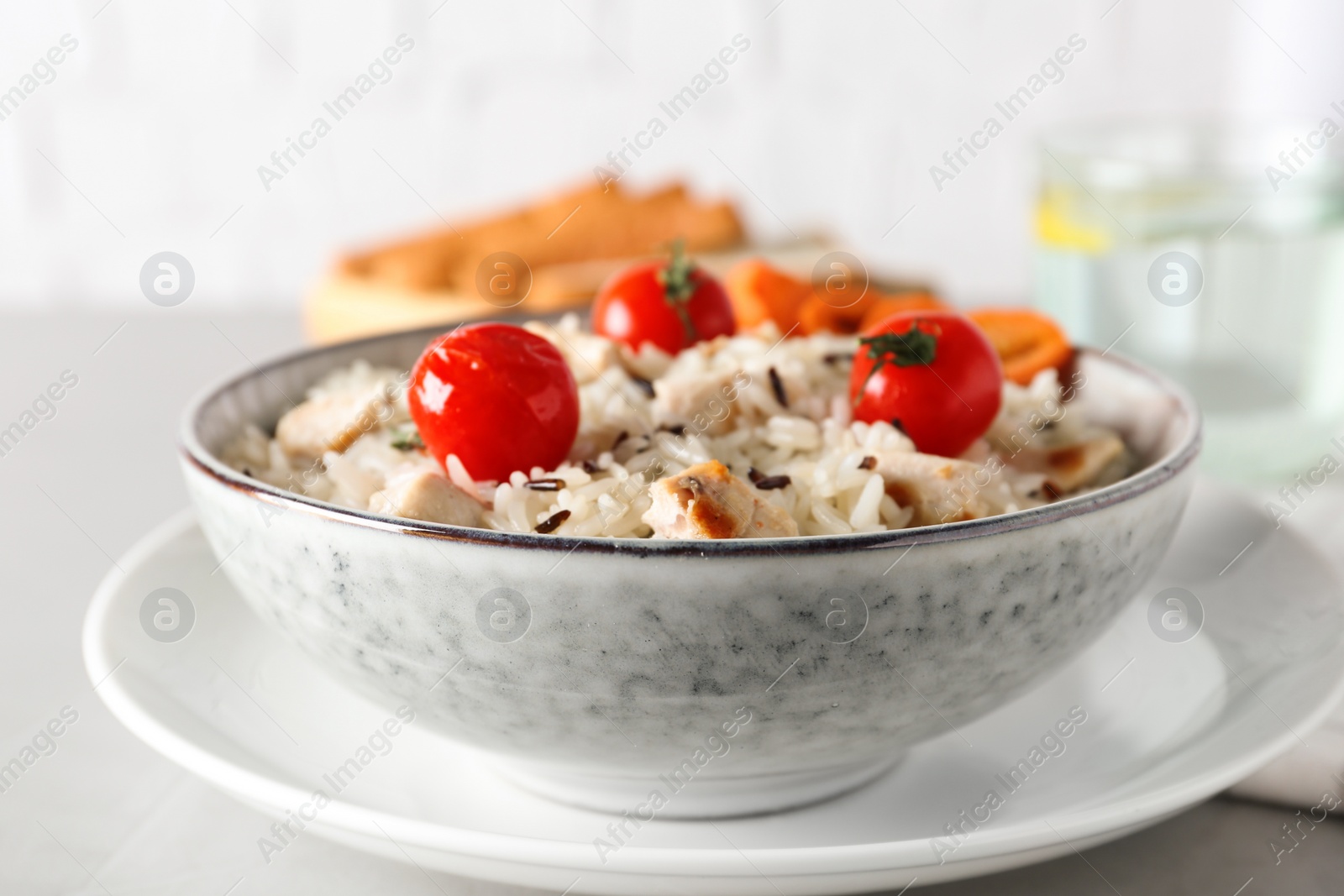 Photo of Delicious rice in bowl served on grey table