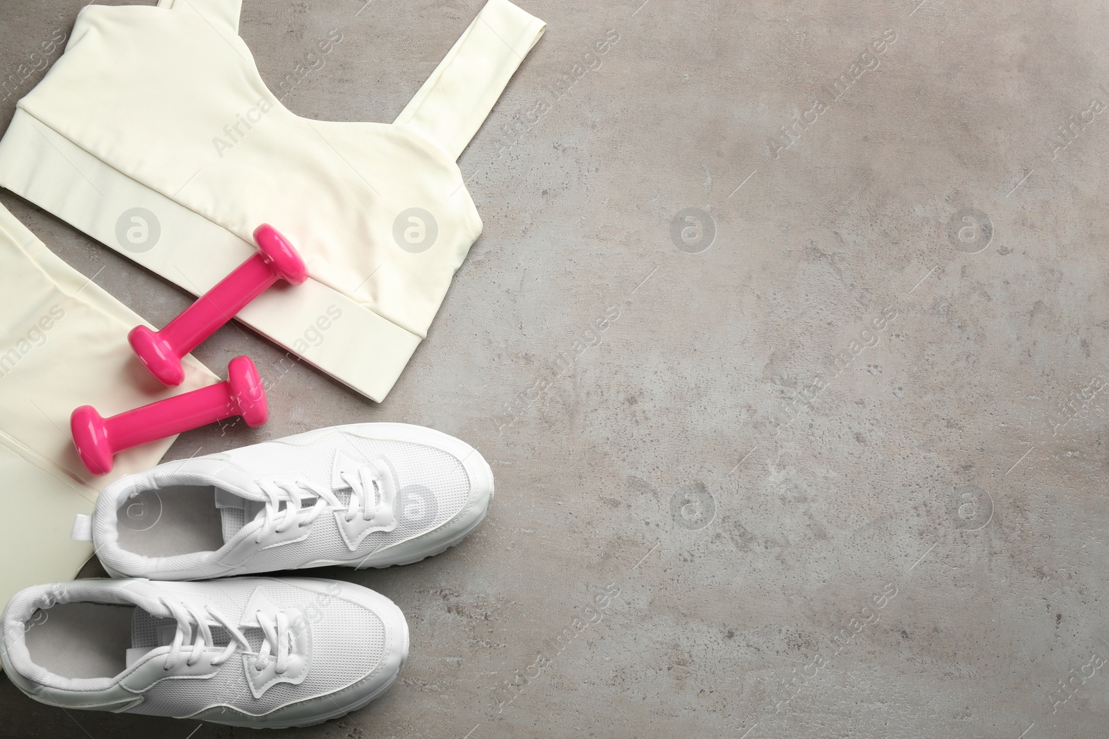 Photo of Flat lay composition with sportswear and equipment on grey table, space for text. Gym workout