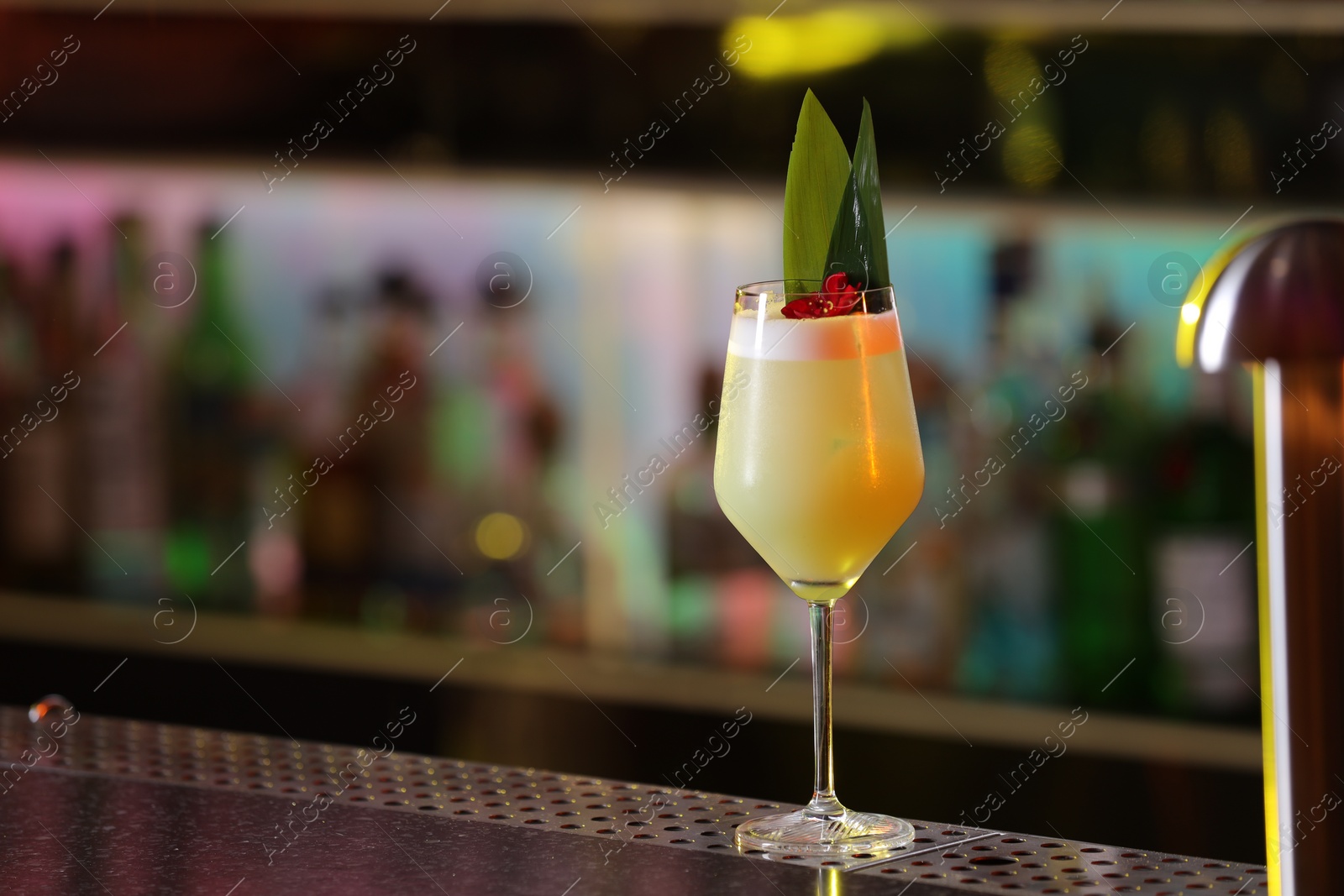 Photo of Fresh alcoholic cocktail in glass on bar counter. Space for text