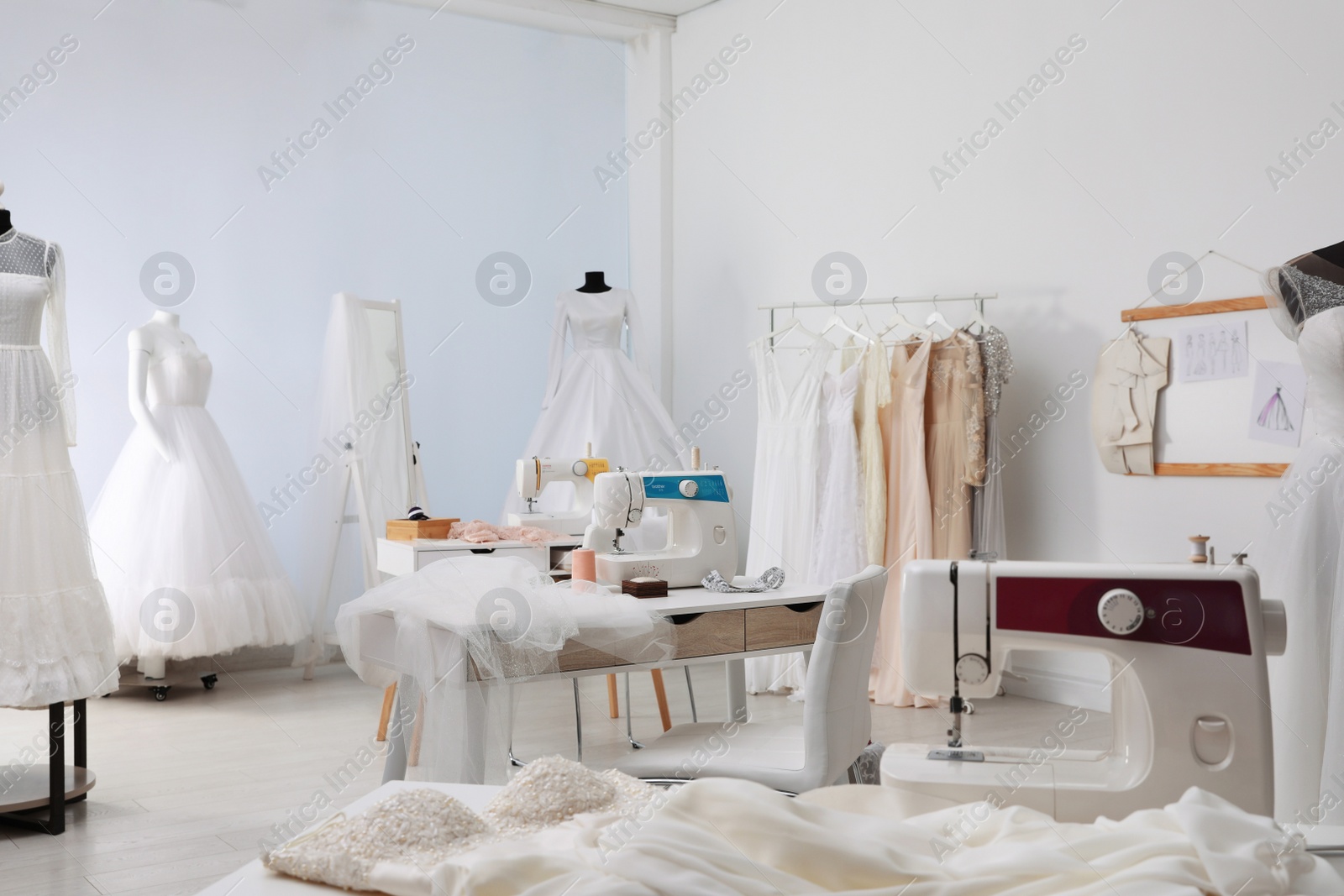 Photo of Dressmaking workshop interior with wedding dresses and equipment