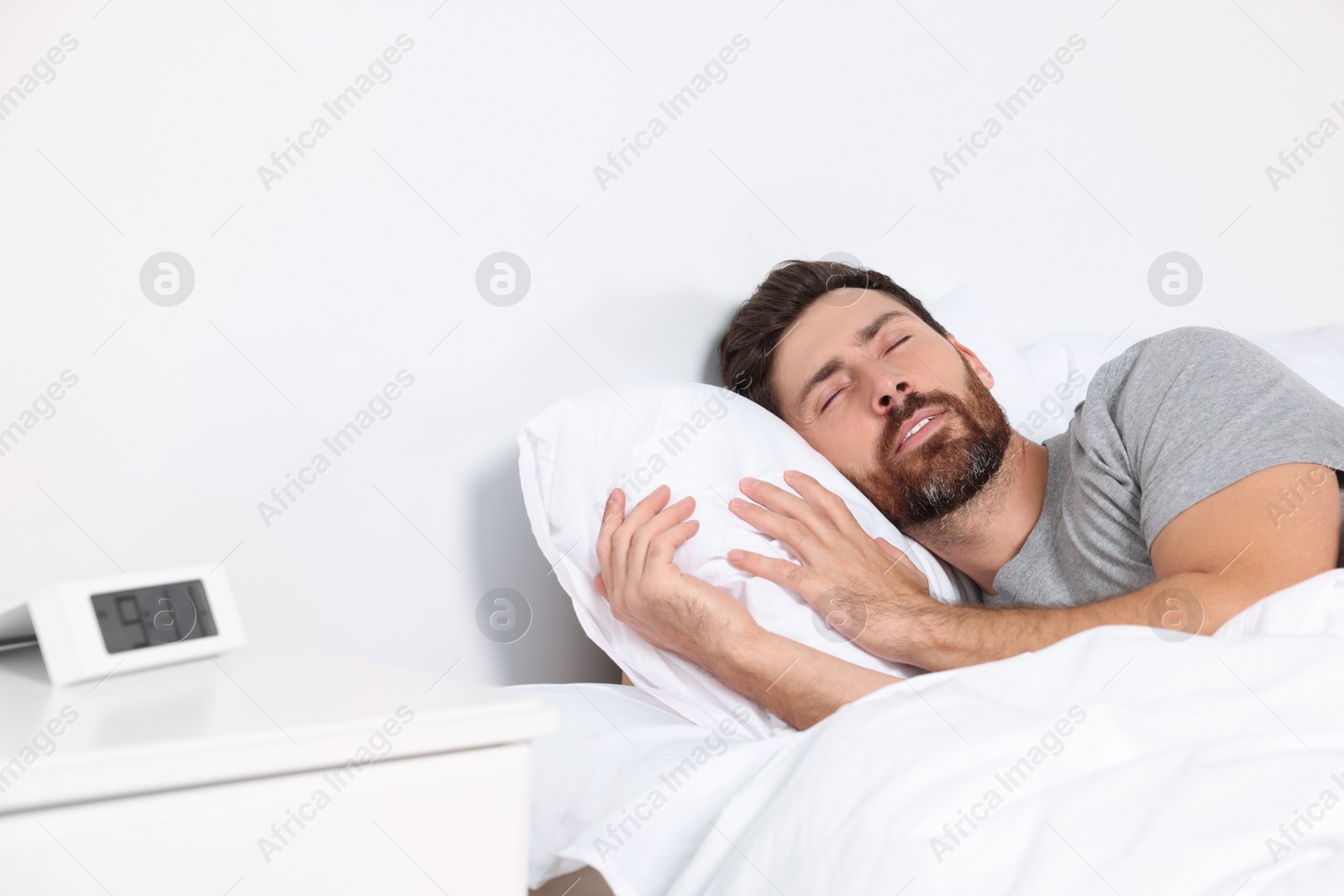 Photo of Man sleeping on comfortable pillows in bed at home