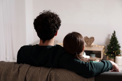 Couple watching movie via video projector at home, back view