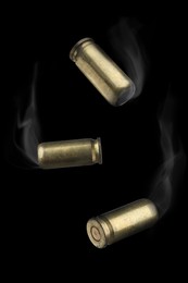 Image of Cartridge cases with smoke falling on black background