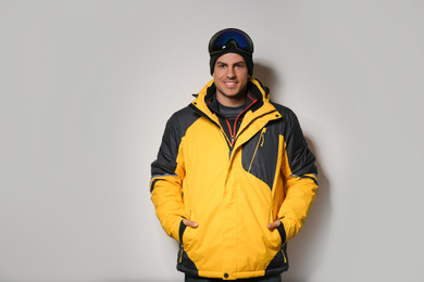 Photo of Man wearing stylish winter sport clothes on light grey background