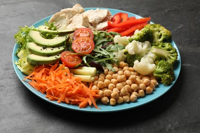 Photo of Balanced diet and healthy foods. Plate with different delicious products on black table