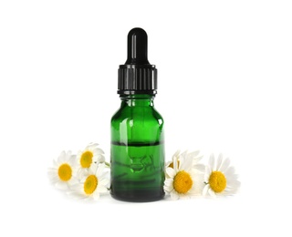 Photo of Bottle of herbal essential oil and chamomile flowers isolated on white