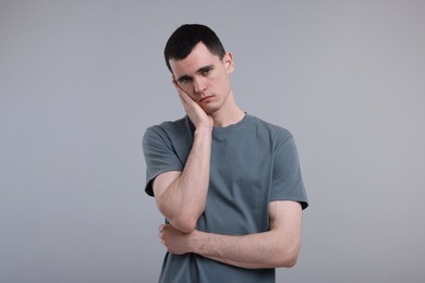 Portrait of sad man on grey background