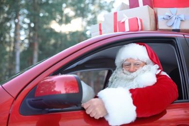 Authentic Santa Claus in red car, view from outside