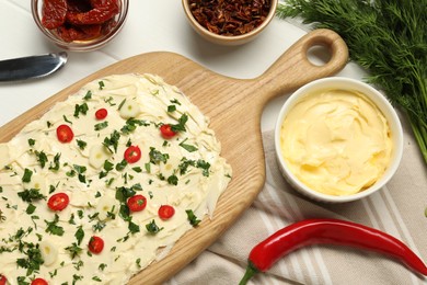 Photo of Fresh natural butter board with pepper, sun-dried tomatoes and dill on white wooden table, flat lay