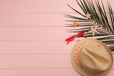 Photo of Flat lay composition with beach objects on pink wooden background, space for text