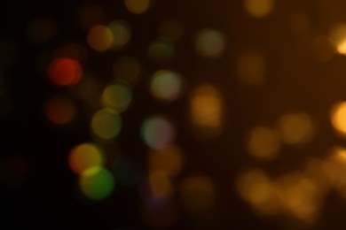 Photo of Blurred view of shiny glitter on black background. Bokeh effect