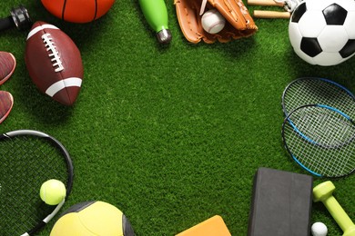 Photo of Frame made of different sports equipment on green grass, flat lay. Space for text