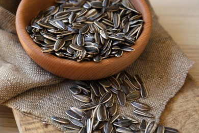 Photo of Organic sunflower seeds on wooden table, closeup
