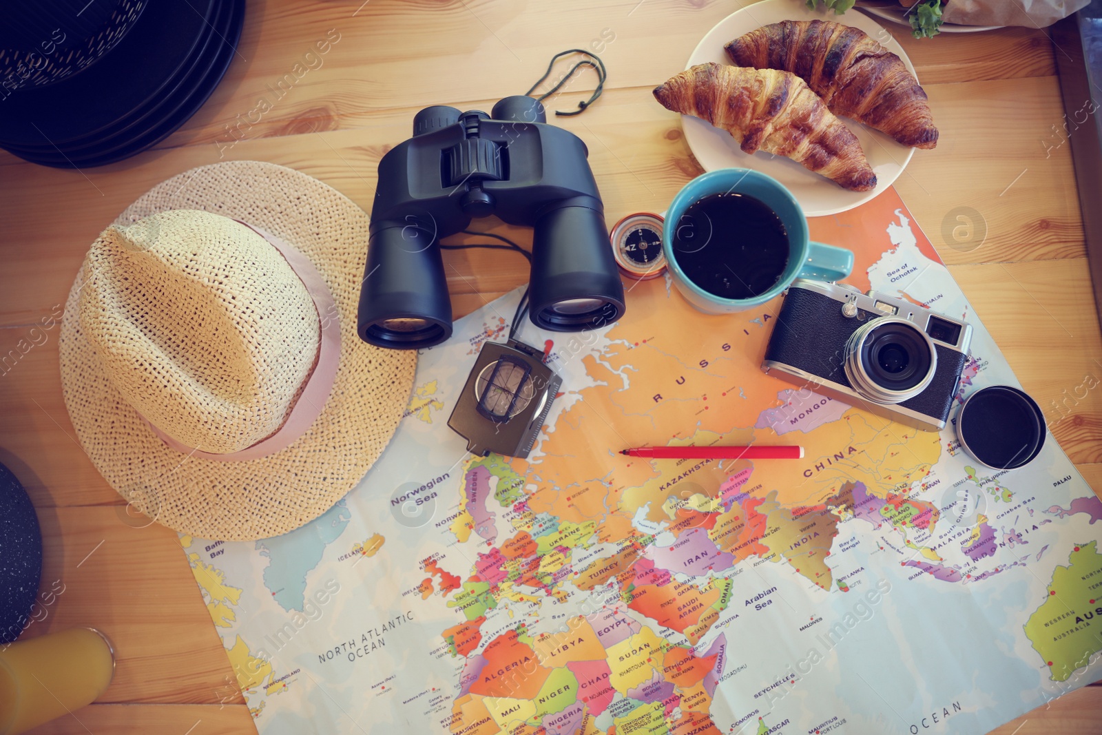 Photo of Flat lay composition with travel accessories on wooden table in motorhome. Summer trip