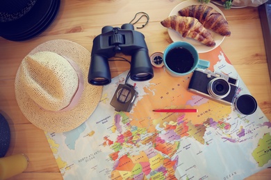 Photo of Flat lay composition with travel accessories on wooden table in motorhome. Summer trip