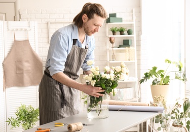 Male florist creating floral composition at workplace