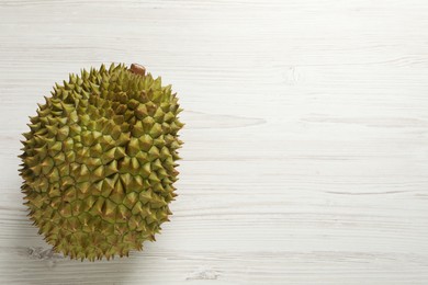 Photo of Ripe durian on white wooden table, top view. Space for text