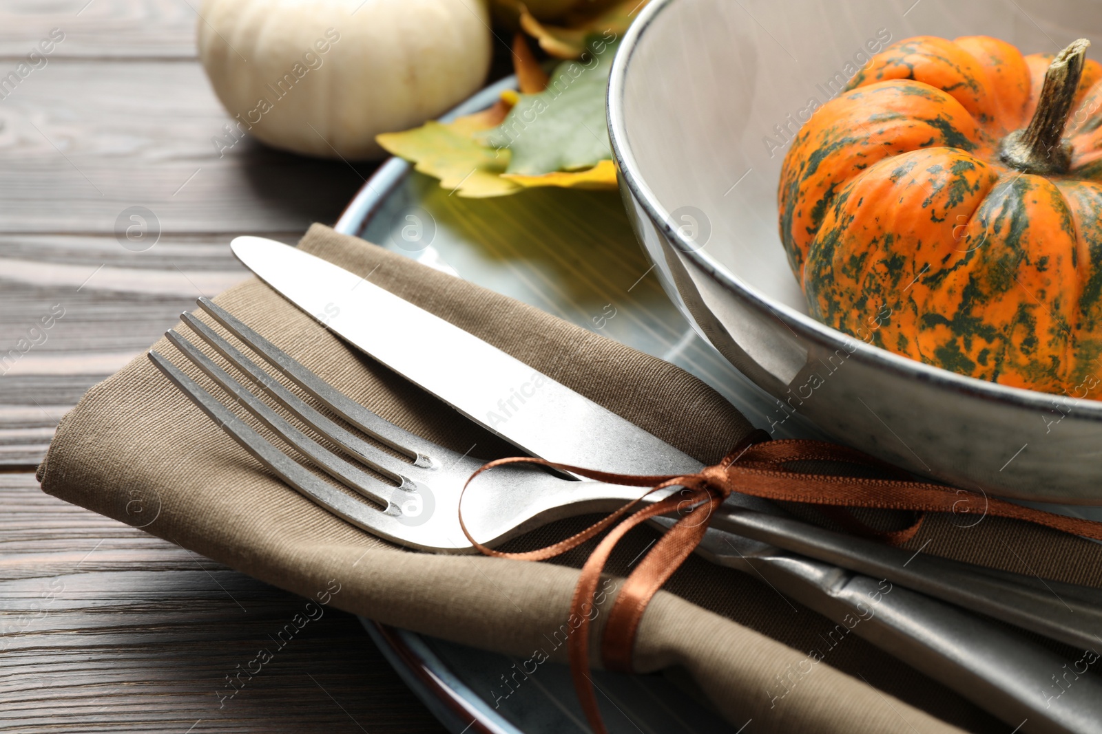 Photo of Festive table setting with pumpkins on wooden background, closeup. Thanksgiving Day celebration