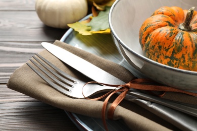 Photo of Festive table setting with pumpkins on wooden background, closeup. Thanksgiving Day celebration