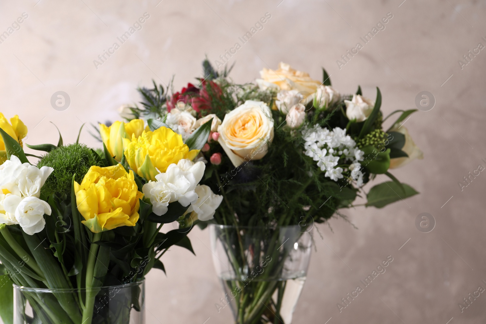 Photo of Beautiful bouquets with fresh flowers on grey background, closeup