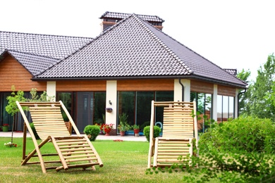 Photo of Wooden deck chairs in beautiful garden on sunny day