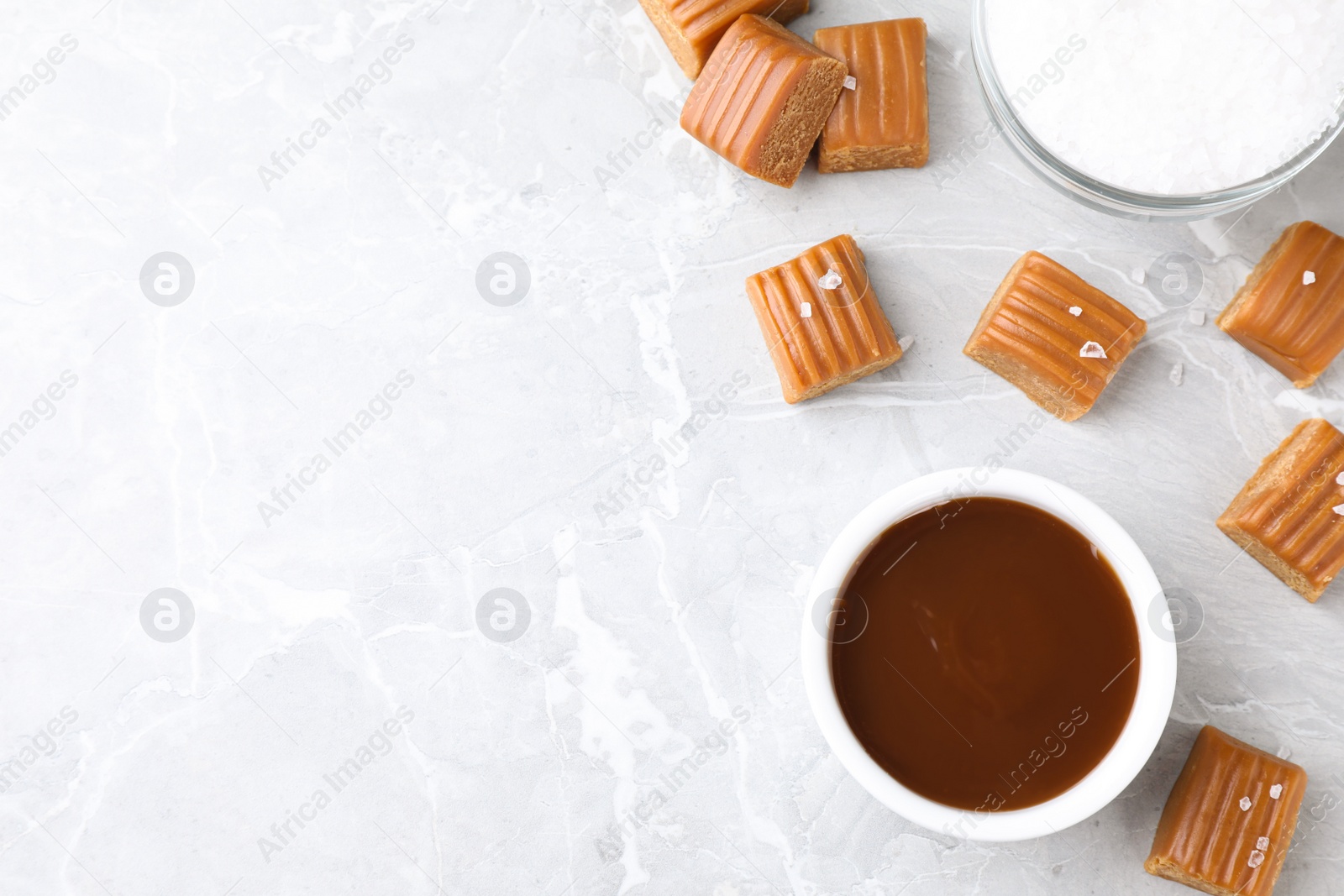 Photo of Salted caramel on marble table, flat lay. Space for text