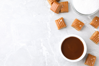 Salted caramel on marble table, flat lay. Space for text