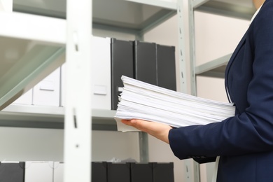 Photo of Female worker with documents in office, closeup