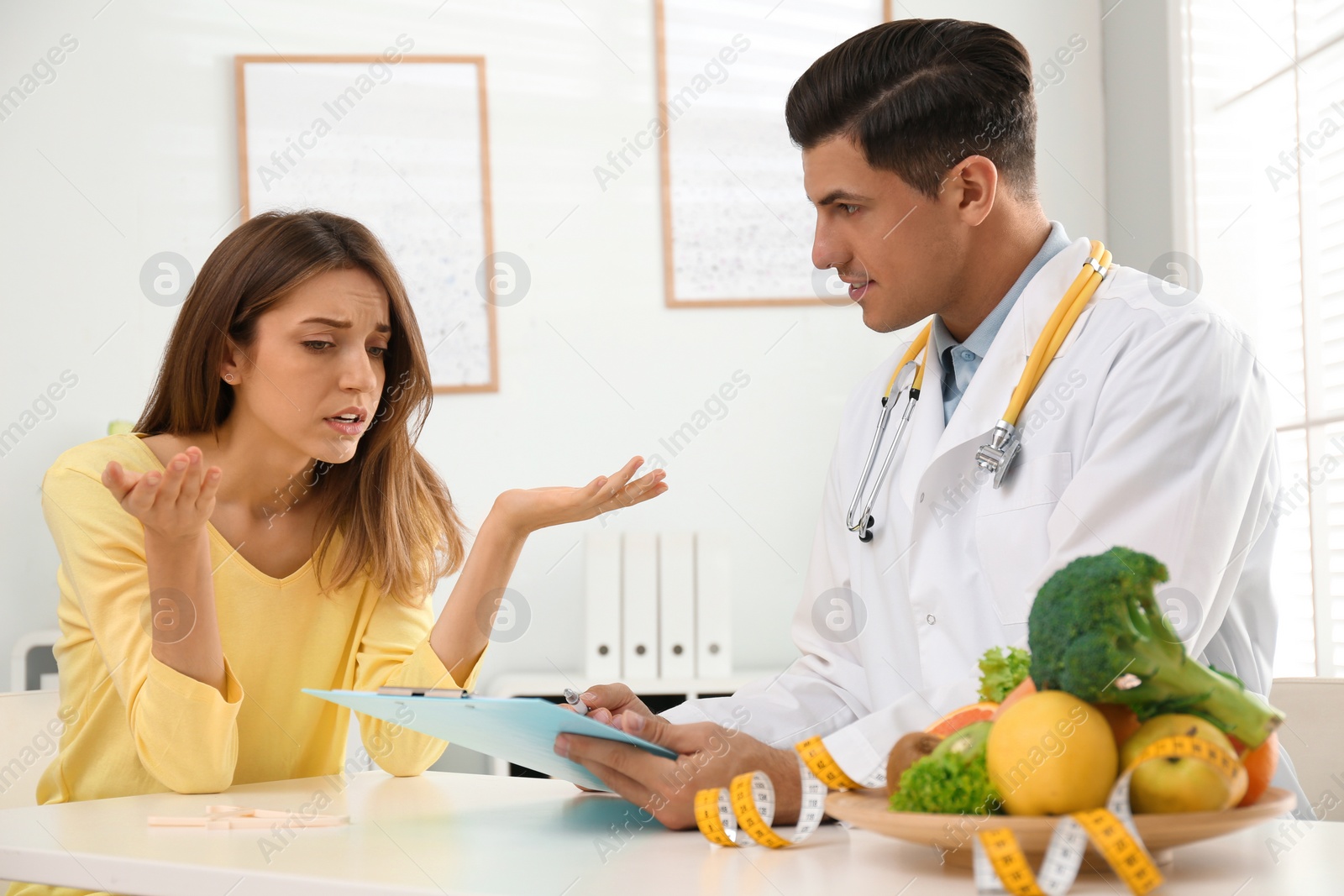 Photo of Nutritionist consulting patient at table in clinic