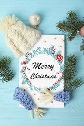 Photo of Flat lay composition with Christmas card and festive decor on light blue wooden background