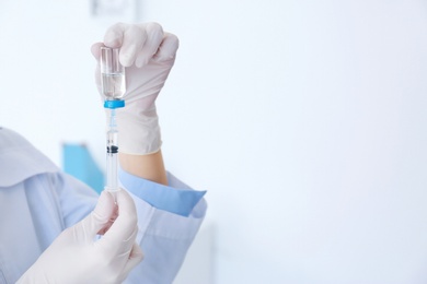 Photo of Female doctor with vial and syringe in hospital. Vaccination day