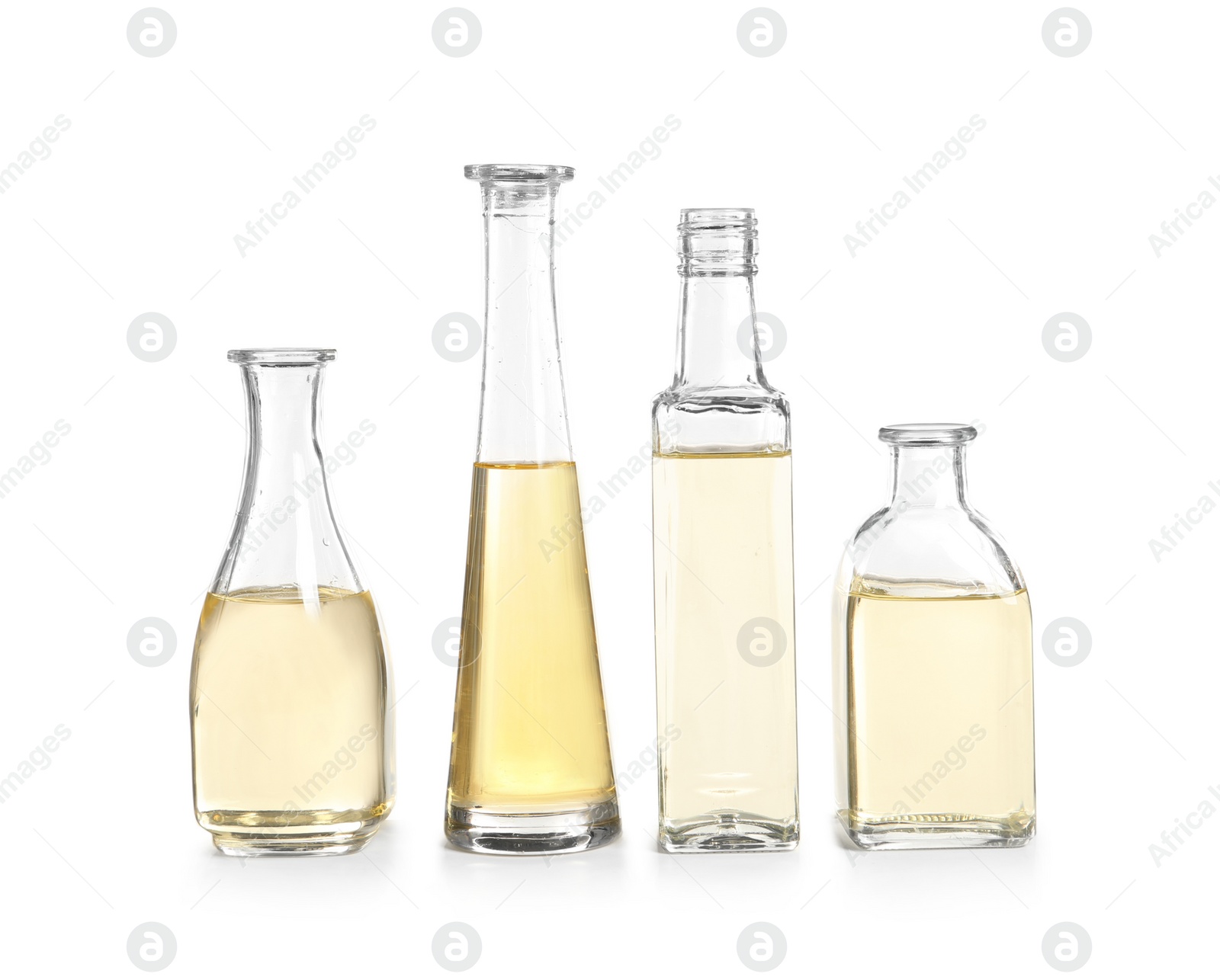 Photo of Row of different glass bottles with oil on white background