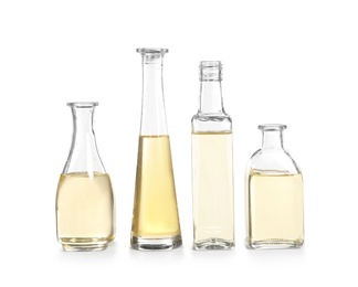 Row of different glass bottles with oil on white background