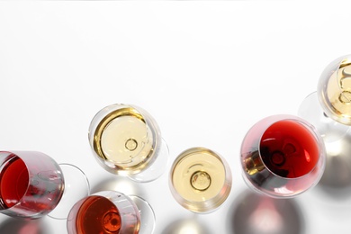 Different glasses with wine on white background, top view