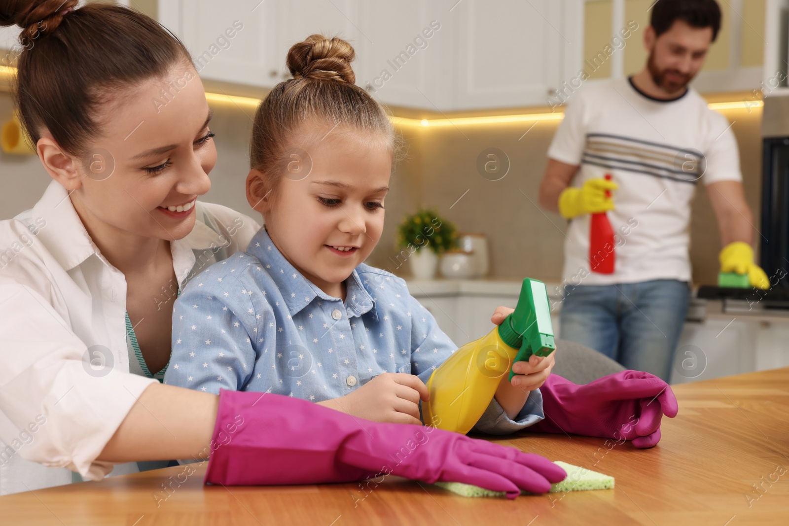 Photo of Spring cleaning. Happy family tidying up kitchen together